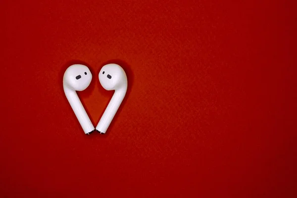 White Wireless Headphones Lie Red Isolated Background Form Heart Top — Stock Photo, Image