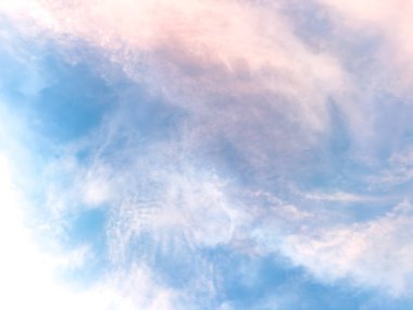 Mavi ve pembe tonlarında yumuşak, pastel bulutlarla dolu huzurlu bir gökyüzü. Bulutlar sakin bir atmosfer yaratıyor, arka plan ya da doğa teması için ideal..