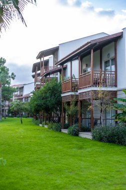 Balkonları yemyeşil çimenler ve tropikal bitkilerle çevrili modern yerleşim yerleri. Banliyö bölgesinde huzurlu bir açık hava.