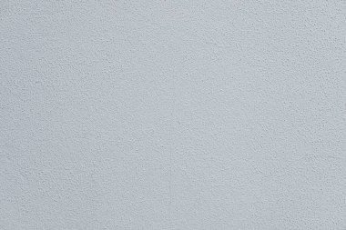 Pürüzsüz, açık gri desenli duvar yüzeyi. Duvarın belli belirsiz, düzgün bir görünüşü var. Görünür bir deseni ya da işareti yok.
