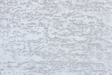 İnce desenli ve ton çeşitliliğine sahip desenli beyaz bir duvar. Yüzey pürüzlü ve düzensiz görünüyor. İlginç bir görsel etki yaratıyor.