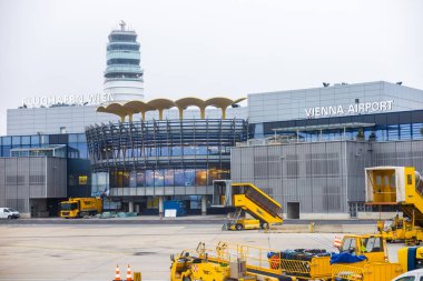 Viyana, Avusturya - 15 Aralık 2025: Modern mimari ile Viyana Uluslararası Havaalanı Terminali, kontrol kulesi ve biniş merdivenleri bulunmaktadır. Sahne bulutlu bir atmosferde geçiyor..