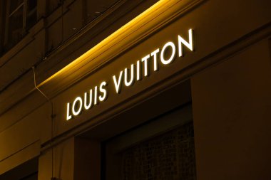 Viyana, Avusturya - 15 Aralık 2025: Viyana, Avusturya 'da gece aydınlanan bir Louis Vuitton mağaza tabelası. İşaret koyu arkaplan üzerinde ikonik LV logosunu içeriyor.