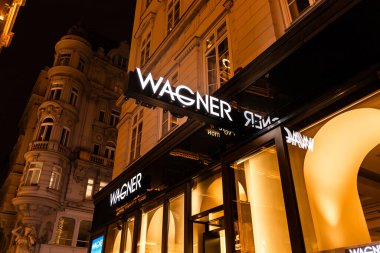 Viyana, Avusturya - 15 Aralık 2025: Viyana, Avusturya 'da Wagner mağaza cephesi. Aydınlatılmış işaret, marka adını şık bir arkaplanda belirgin bir şekilde gösterir.