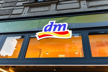 Viyana, Avusturya - 15 Aralık 2025: Viyana, Avusturya 'da bir mağaza cephesinde DM logosunun yakın çekimi. Logoda popüler bir perakende zincirini temsil eden cesur renkler ve modern bir tasarım yer alıyor..