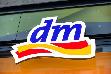 Viyana, Avusturya - 15 Aralık 2025: Viyana, Avusturya 'da bir mağaza cephesinde DM logosunun yakın çekimi. Logoda popüler bir perakende zincirini temsil eden cesur renkler ve modern bir tasarım yer alıyor..