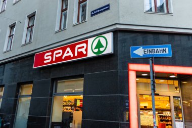 Viyana, Avusturya - 15 Aralık 2025: Avusturya 'nın Viyana kentinde bir spor marketi. Mağaza vitrininde belirgin bir kırmızı ve yeşil tabela var. Sokak tabelası tek yönlü bir yol olduğunu gösteriyor..