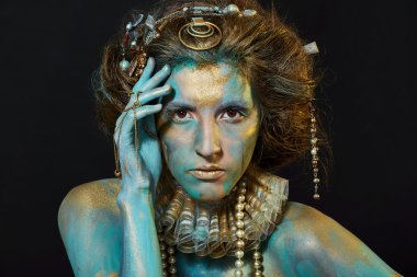 Altın ve yeşil vücut sanatı ile model. 