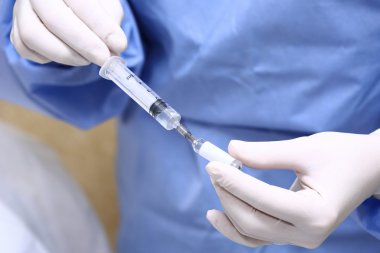 Şırıngayı dolduran doktorların elleri.