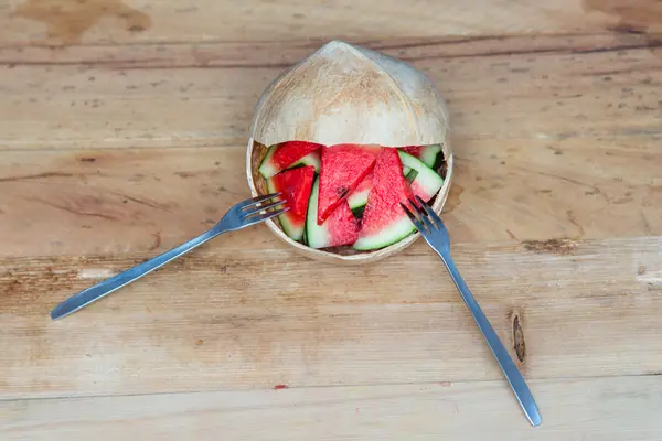  Bir Hindistan cevizi ahşap masa üzerinde karpuz dilimleri. 