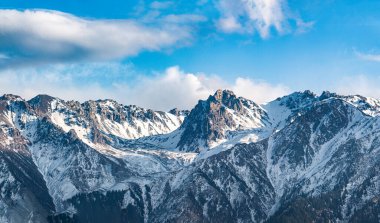 Dağları ve mavi gökyüzü olan güzel bir manzara.