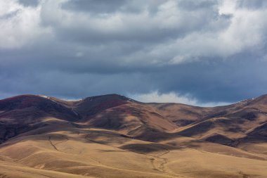 Bulutlu gökyüzünün arka planında bir dağ olan güzel bir manzara