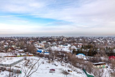 Kış manzaralı, karla kaplı bir şehir ve akşamları binalar.