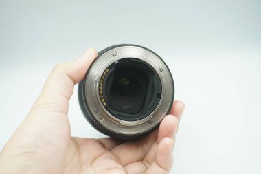 Beyaz arka planda mantar olmadan kameranın lensini ters çeviren bir el..