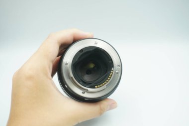 Beyaz arka planda mantar olmadan kameranın lensini ters çeviren bir el..