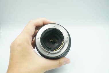 Beyaz arka planda mantar olmadan kameranın lensini ters çeviren bir el..