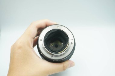 Beyaz arka planda mantar olmadan kameranın lensini ters çeviren bir el..