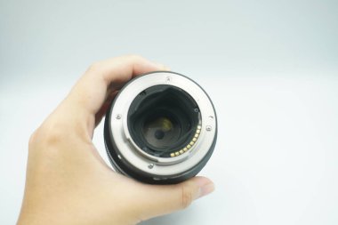 Beyaz arka planda mantar olmadan kameranın lensini ters çeviren bir el..