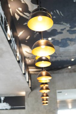 Sarı ışıklı minimalist estetik tasarımı olan kase şeklinde dekoratif asılı lamba.