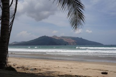 Gün boyunca Mustika Sahili 'nin kıyısından, Banyuwangi' nin tepelerine bakın.