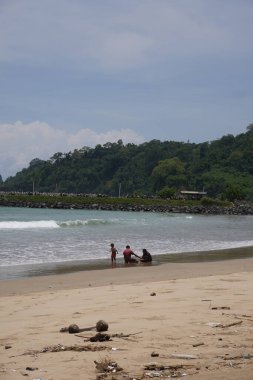 Gün boyunca sahilde birlikte oynayan bir aile.
