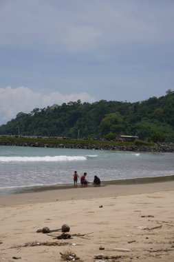 Gün boyunca sahilde birlikte oynayan bir aile.