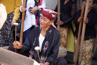 Endonezya, Banyuwangi 'de geleneksel bir müzik aleti çalan yaşlı bir adam.