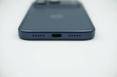 iPhone 17 'nin ses hoparlörü delikleri ve tip-c şarj deliği Beyaz arkaplan ile derin mavi varyant