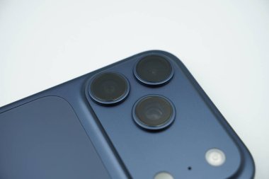 iPhone 17 'de üç kamera lensi var. Derin mavi, beyaz arkaplan.