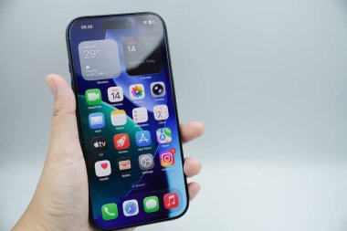 iPhone 17 Pro 'yu tutan bir sol el beyaz arkaplan ile ana sayfayı gösteriyor.