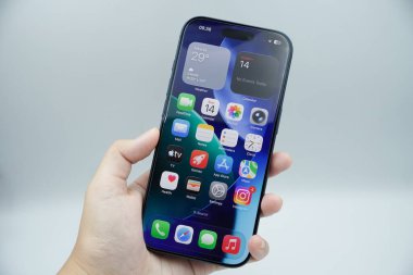 iPhone 17 Pro 'yu tutan bir sol el beyaz arkaplan ile ana sayfayı gösteriyor.