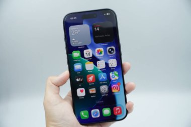 iPhone 17 Pro 'yu tutan bir sol el beyaz arkaplan ile ana sayfayı gösteriyor.