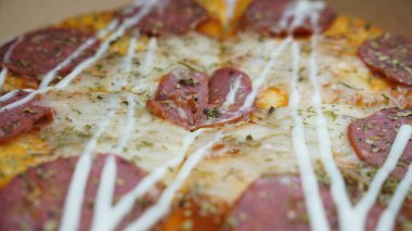 Pizzanın ortasında sucuklu biftek, mozzarella peyniri ve mayonez var..