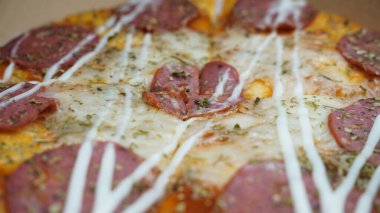 Pizzanın ortasında sucuklu biftek, mozzarella peyniri ve mayonez var..