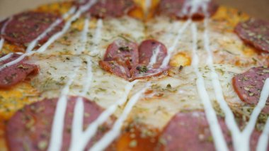 Pizzanın ortasında sucuklu biftek, mozzarella peyniri ve mayonez var..