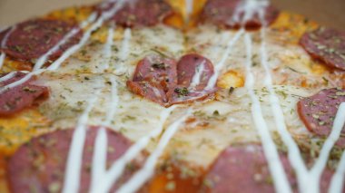 Pizzanın ortasında sucuklu biftek, mozzarella peyniri ve mayonez var..