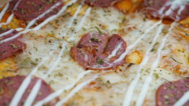 Pizzanın ortasında sucuklu biftek, mozzarella peyniri ve mayonez var..