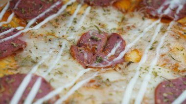 Pizzanın ortasında sucuklu biftek, mozzarella peyniri ve mayonez var..