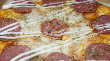 Pizzanın ortasında sucuklu biftek, mozzarella peyniri ve mayonez var..