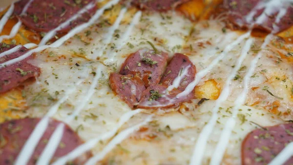 Pizzanın ortasında sucuklu biftek, mozzarella peyniri ve mayonez var..