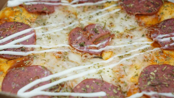 Pizzanın ortasında sucuklu biftek, mozzarella peyniri ve mayonez var..