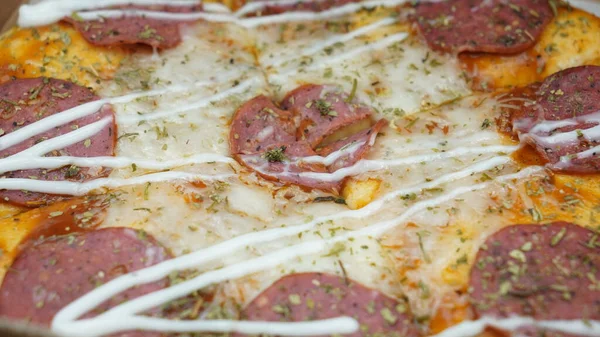 Pizzanın ortasında sucuklu biftek, mozzarella peyniri ve mayonez var..