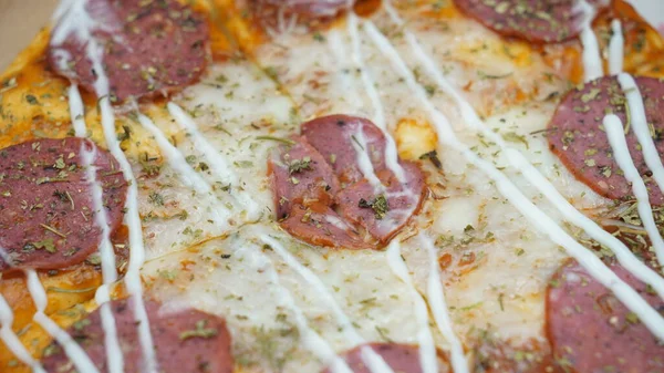 Pizzanın ortasında sosis, mozarella peyniri ve mayonez var.