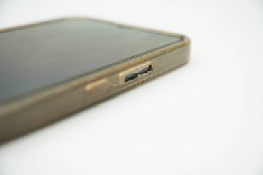 Dosyası beyaz arkaplan ile yırtılmış ve sarıya boyanmış bir akıllı telefonun ses tuşu bölümü