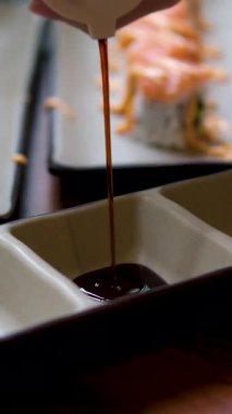 Asian Japanese soy sauce, Dark brown soy sauce pouring down into the glass bowl close up. High quality 4k footage