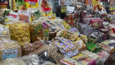 Yerel markaların sattığı geleneksel Vietnam pazarı kurutulmuş meyve, şeker, abur cubur ve renkli paketlerle dolu parlak tezgahlarda el yapımı tatlılar satıyordu. Vietnam Da Nang 11.2025