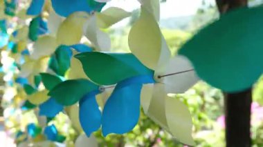 Ağaç dalından sarkan renkli kağıt fırıldaklar neşeli bir atmosfer yaratıyor. Yüksek kalite 4k görüntü