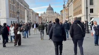 Roma 'da Vatikan yakınlarındaki caddelerde gezen turistler, tarihi cephelerin yanında yemek yiyor ve sırada bekliyorlar. İtalyan mimarisi Roma, İtalya 11.30. 2025