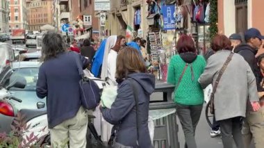 Roma 'da yürüyüp sohbet eden bir grup rahibe İtalyan şehrinde günlük hayatın doğal sakin bir anını gösteren bir sokak satıcısında pizza seçiyor. Roma, İtalya 11.30. 2025