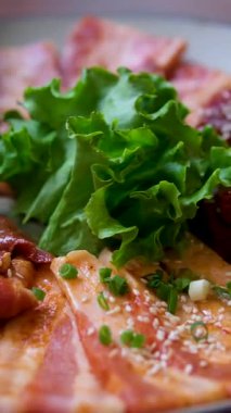 Çıtır domuz bifteği, tavuk bifteği, sulu sosis, kızarmış yumurta, lahana salatası ve garnitürlü marul içeren iştah açıcı kahvaltı tabağı. Sabah yemeklerini ya da geleneksel rahatlığı temsil etmek için mükemmel..